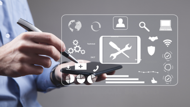 Cilvēks gaiši zilā kreklā tur viedtālruni un ar irbuli pieskaras ekrānam. Virs tālruņa redzams caurspīdīgs digitālais interfeiss ar tehniskā atbalsta un servisa ikonām, piemēram, sakrustotu uzgriežņu atslēgu un skrūvgriezi, zobratiem, globusu, telefona klausuli un datu diagrammām.