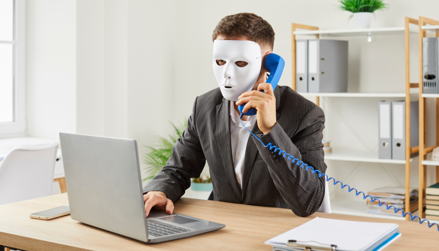 cilvēks maskā runā pa telefonu