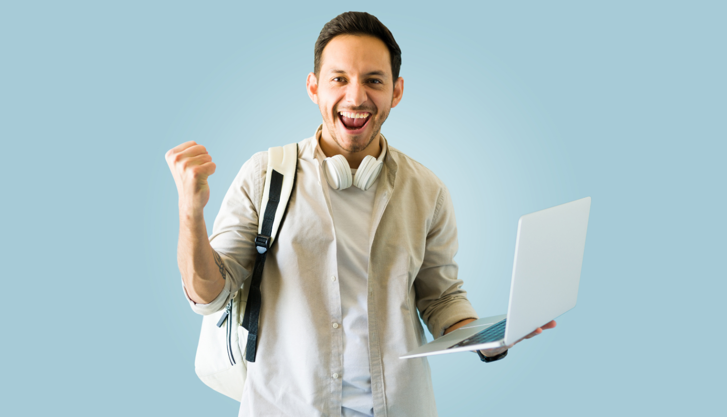 Priecīgs students ar portatīvo datoru rokās